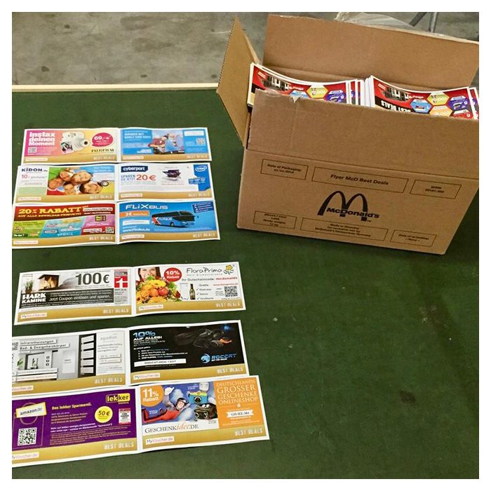 Coupons des McDonald's Voucher Booklets BEST DEALS neben einem McDonald's-Versandkarton